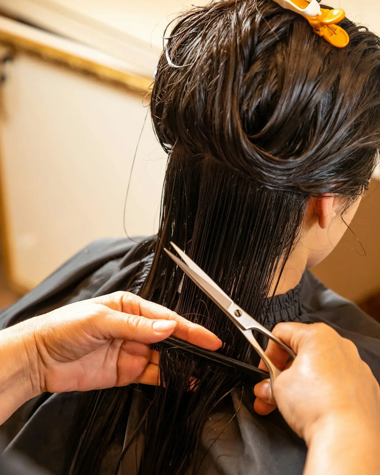 Cosmetology student precision-cutting wet hair, part of the 1000-hour Cosmetology Operator curriculum