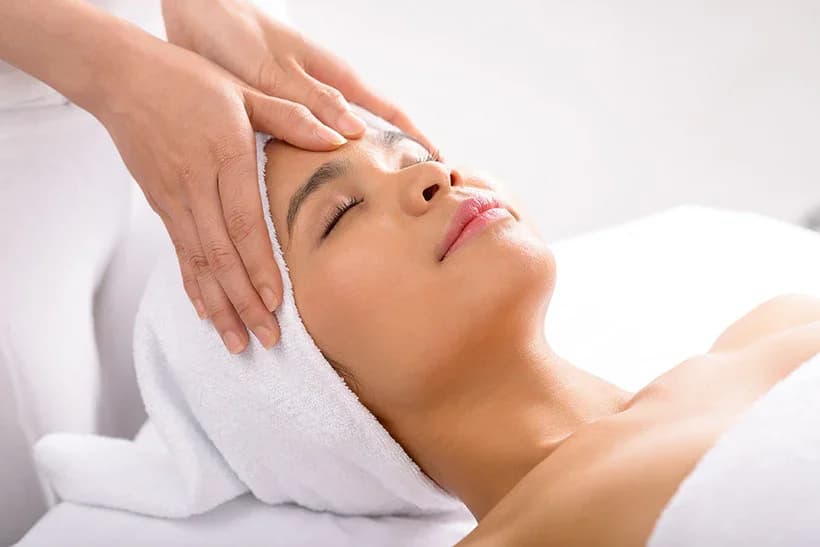 Esthetics student performing a relaxing professional facial, part of the 750-hour Esthetician skincare curriculum